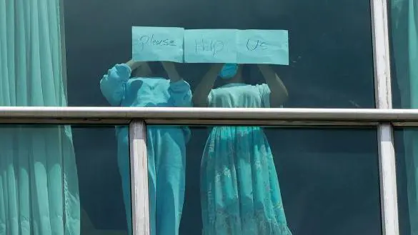299 Los migrantes deportados buscan ayuda a través de ventanas en un hotel en Panamá